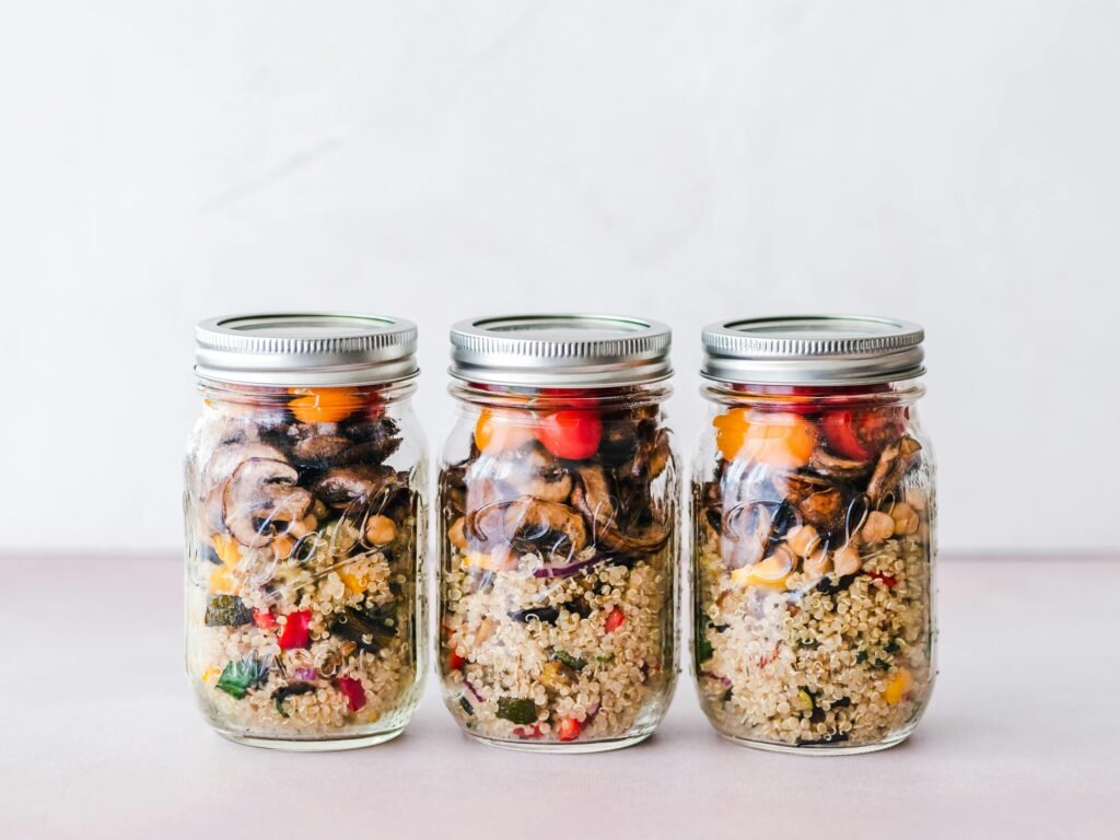 Colorful quinoa salad jar with roasted veggies, ideal for healthy meal prep.