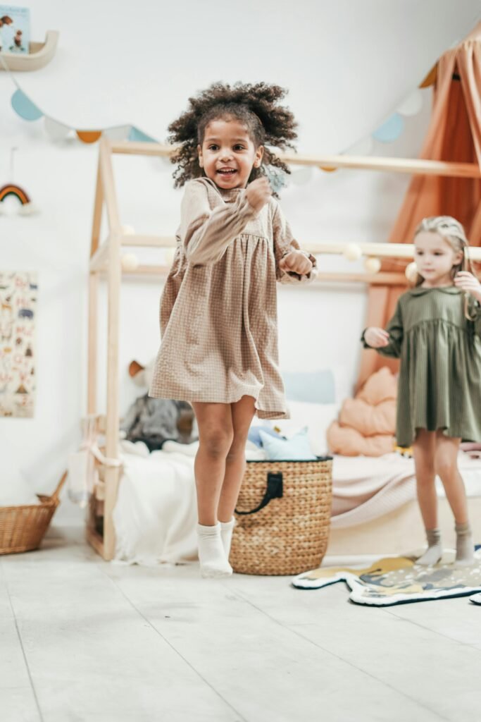 Happy children jumping and playing indoors, expressing joy and innocence in a colorful playroom.